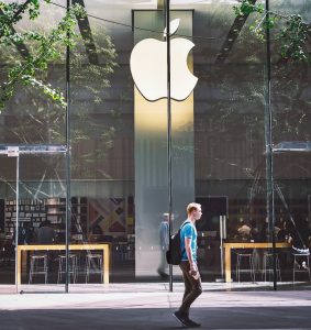 Man walking past an Apple store