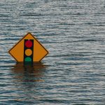 Photo of a street sign, half submerged in water